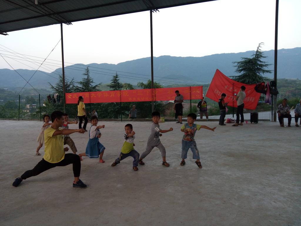 志愿者们教授小朋友武术五步拳的基本动作