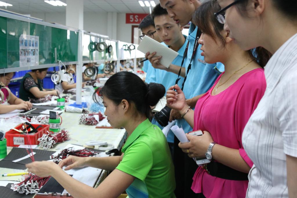 实践团成员仔细观察电子产品制作工序